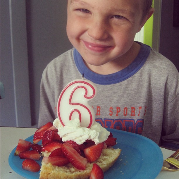 little boy turning six birthday cake candle