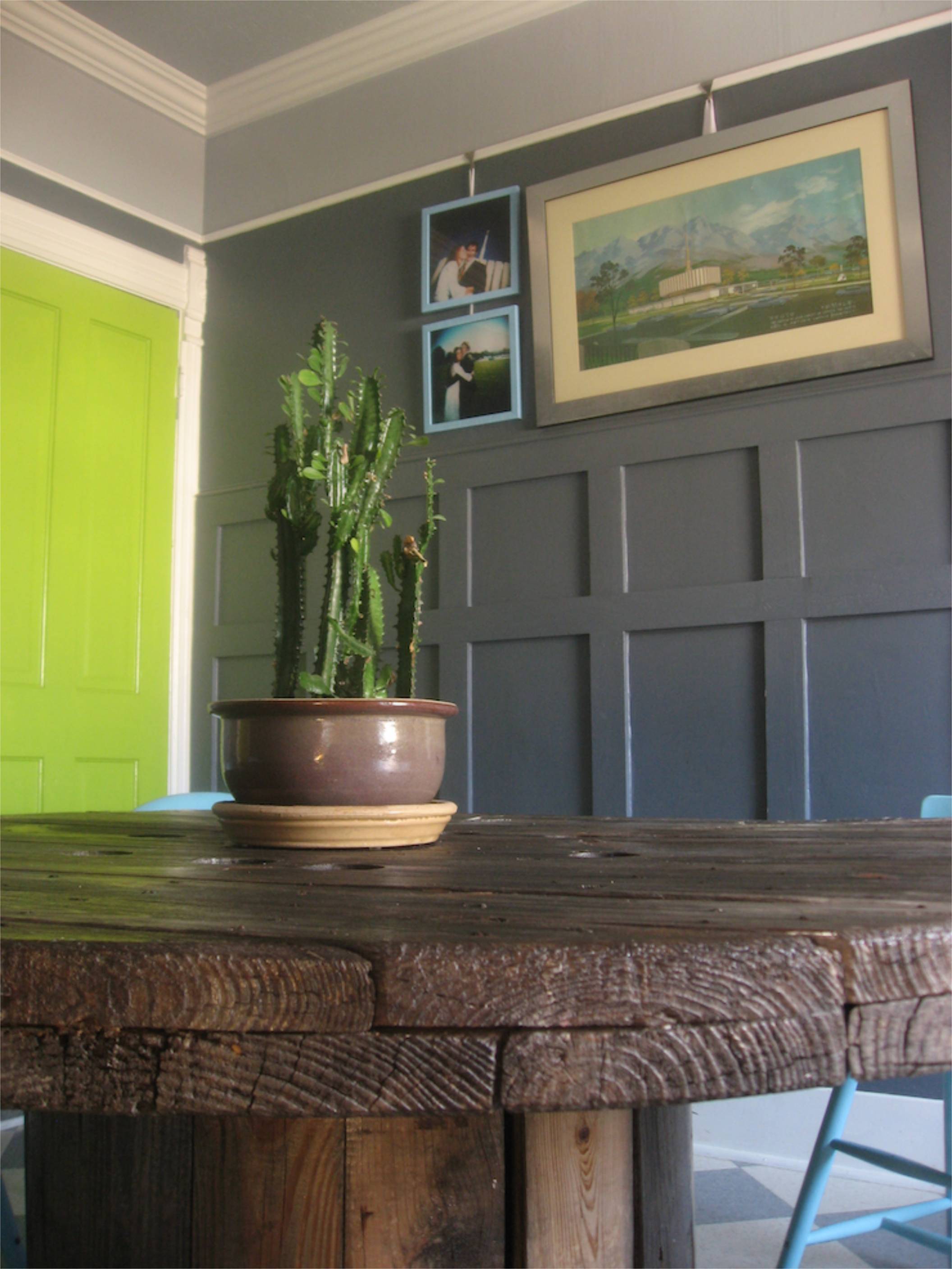 wooden spool dining table grey wainscoting chartreuse door